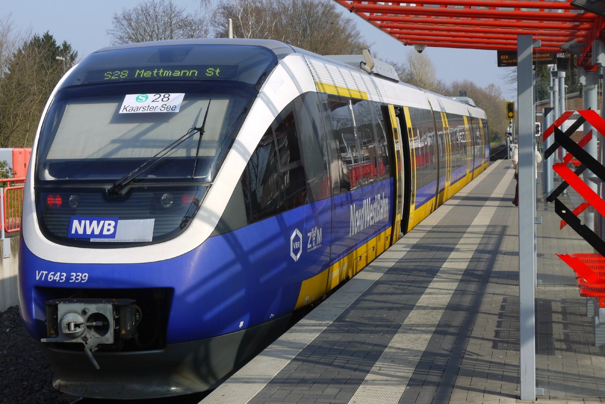 Ersatzfahrzeug 643 339 als S 28 in der Station Kaarster Bahnhof am 8.4.15. Zutreffend war die digitale Anzeige: der Zug war nach Mettmann unterwegs. Die Zettel stammen aus der Zeit, als das Infosystem noch nicht auf die neue Verwendung des Wagens programmiert war.