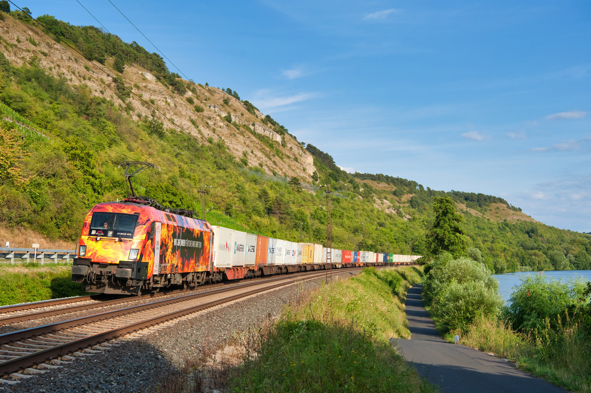 ES 64U2-072 TXL  Wir brennen für das was wir tun  mit einem Containerzug bei Gambach Richtung Gemünden, 01.08.2019
