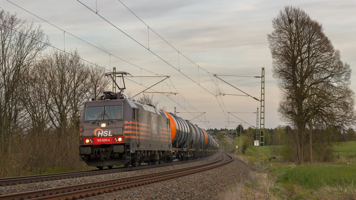 Es ist schon abends am 24. April 2017. Kurz vor dem Bahnhof Syrau kommt ein Kesselzug der HSL mit 185 600-4. 