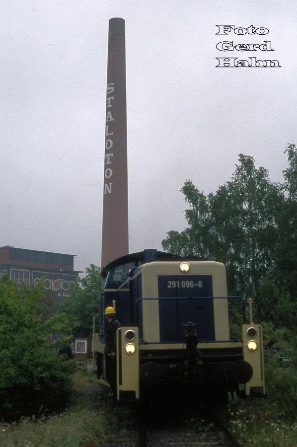 Es war einmal! - Am 7.6.1988 bediente 291096 morgens um 7.35 Uhr die Staloton Werke im Industriegebiet Westerkappeln - Velpe.
Heute ist der Schlot mit dem markanten Schriftzug abgetragen. Die Gleise im Werk sind zugestellt. Der Abzweig vom Bahnhof Velpe aus ist mehr oder minder zugewachsen. Es gibt schon seit vielen Jahren keinen Zugverkehr mehr auf diesem Anschlussgleis.