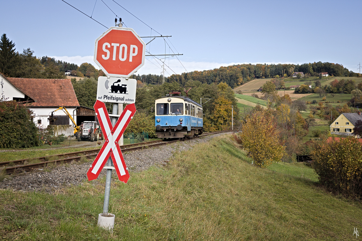 ET1 bei seiner Sonderfahrt zwischen Oedt bei Feldbach und Prädiberg. Bemerkenswert ist, dass auf der Gleichenbergerbahn noch schöne Andreaskreuze vorhanden sind, während anderer Orts nur noch rechteckige weiße Tafeln mit einem aufgemalten Andreaskreuz vorhanden sind. (23.10.2021)