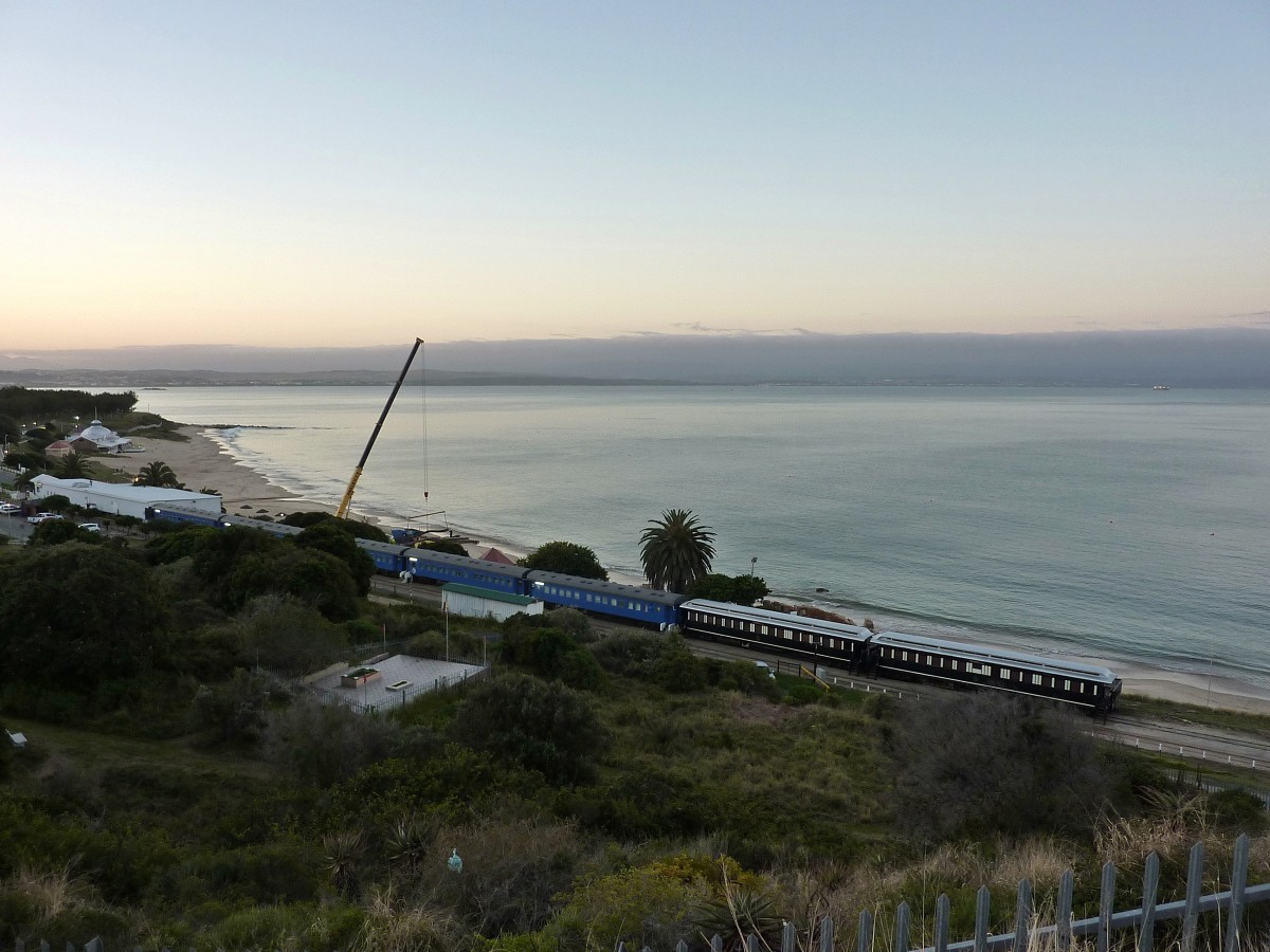 Etliche Schlafwagen werden in Mossel Bay als Unterkunft genutzt. Die Wagen wurden in den hauptsächlich 70er Jahren gebaut und wurden weitgehend im Originalzustand belassen. Das Bahngleis rechts führt zum kleinen Hafen von Mossel Bay und wird noch von Güterzügen befahren. Aufgenommen am 12.09.2014.