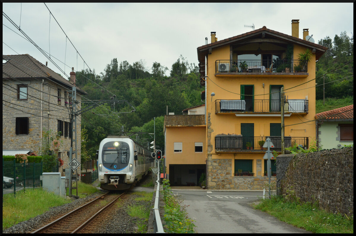 Euskotren Trena: Die enge Ortsdurchfahrt von Txokoalde wird von einem CAF-Triebzug der BR 900  pünktlich in Richtung Bilbao Matiko gemeistert. 16.08.2023
