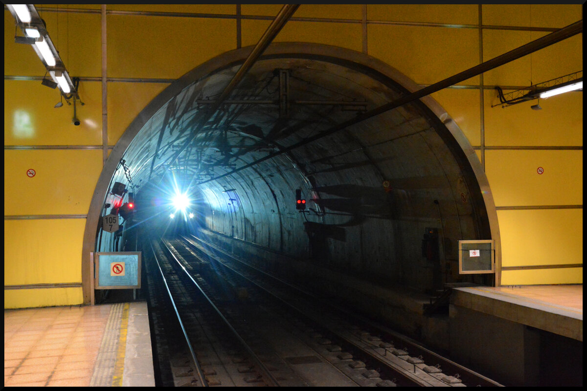 Euskotren Trena: Ein CAF-Triebzug der BR 900 kommt mit Fernlicht durch den Tunnel aus Richtung Amara in die nordöstliche Einfahrt des Bahnhof Lugaritz in San Sebastian (baskisch: Donostia). 16.08.2023