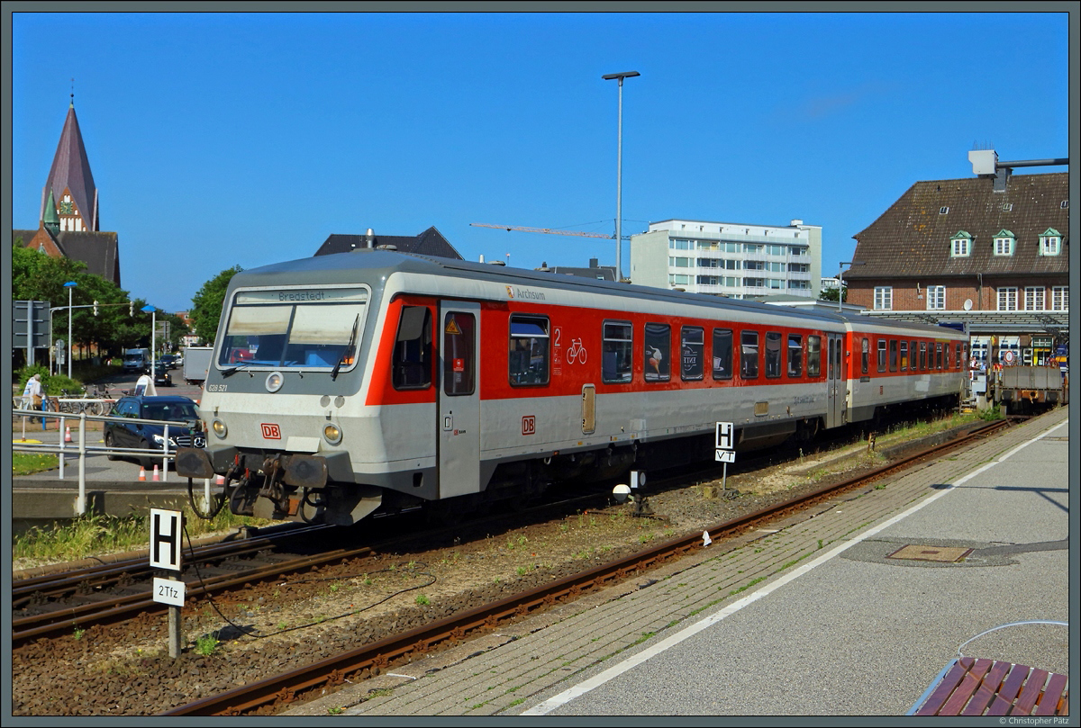 Extra für den Syltshuttle Plus entstand in Westerland am Gleis 5 ein kurzer Bahnsteig. 628 521  Archsum  steht am 02.07.2021 an diesem zur Rückfahrt nach Bredstedt bereit. Links im Hintergrund steht die St. Nicolai-Kirche, die größte Kirche der Insel.