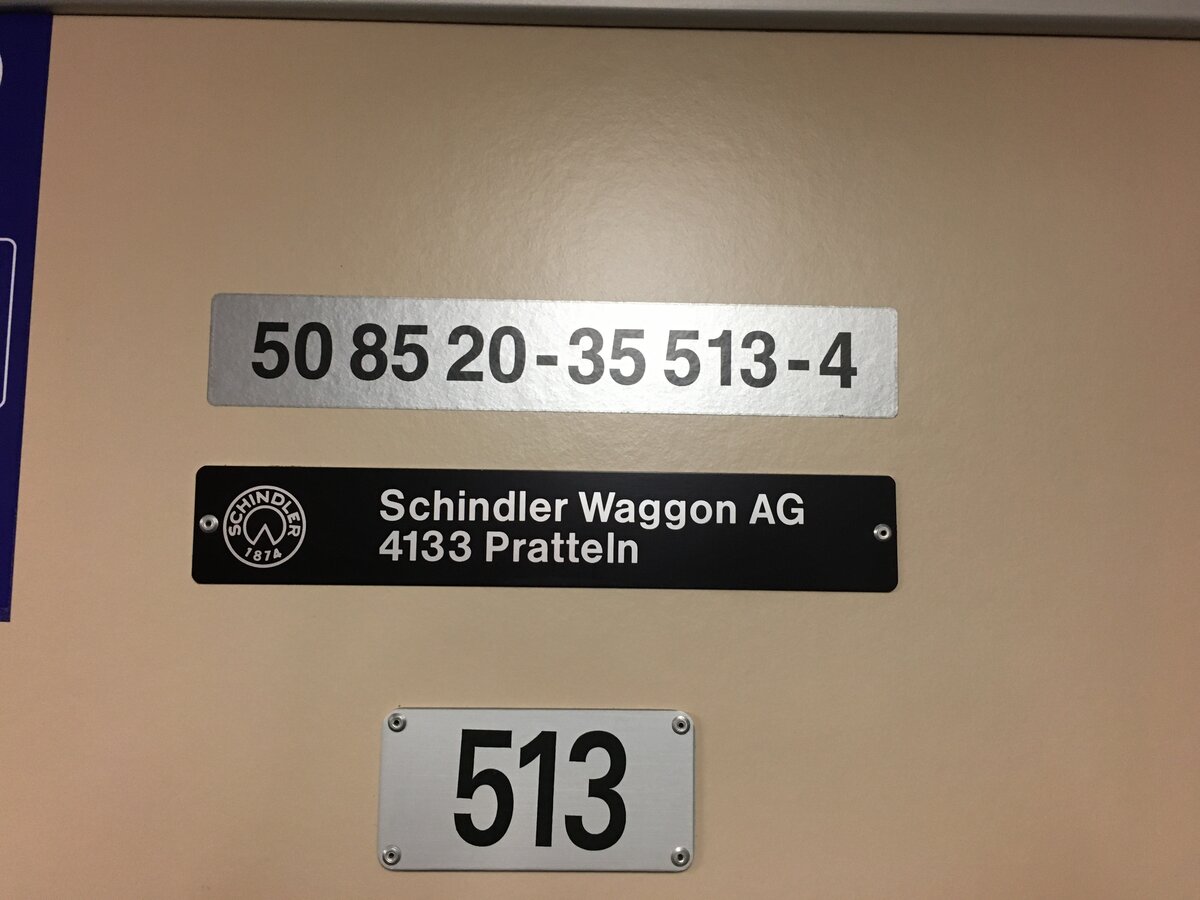 Fabrikschild der Schinder Waggon AG und Nummer sowie Bezeichnung des Wagens.
Fotografiert in einer Komposition der BLS, Typs RBDe 566.
Fotografiert am 28.12.21