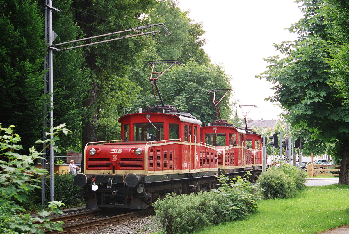 Fährt man in Laufen über die Grenze nach Österreich, führt die Straße nach wenigen Metern durch den kleinen Stadtpark von Oberndorf. Hat der Bahnfan Glück - der Eilige sagt Pech - blinkt es am Bahnübergang und ein schriller Pfiff warnt die Wartenden. Die Salzburger Lokalbahn rauscht vorüber. Ich hatte am 17. Juni 2005 das Glück, gleich 3 Güterloks vor die Linse zu bekommen. E 61 führte, E63 steckte in der Mitte und E 62 bildete den Schluss des nach Salzburg fahrenden Trios.