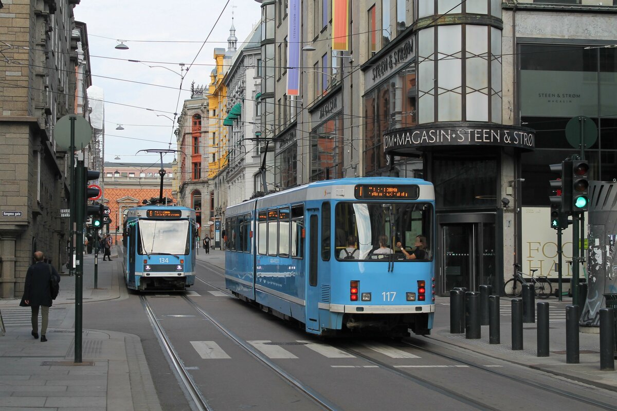 Fahrzeug 134 (Serie II) und eine Heckansicht von Fahrzeug 117 (Serie I), beide jedoch von ABB Strømmen gebaut, am 24.8.2022 in der Prinsens gate. 