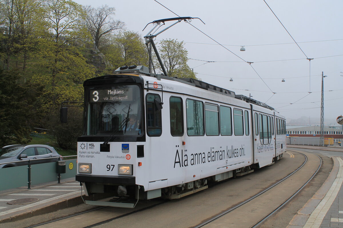 Fahrzeug 97 der HKL/HST vom Typ Valmet MLNRV 2 mit Werbelackierung von Pohjola Vakuutus auf der Linie 3 (Olympiaterminaali – Meilahti) am 12.5.2022 an der Starthaltestelle Olympiaterminaali der Linie 3. An dieser Haltestelle übernehmen die Fahrzeuge der Linie 2 jeweils die Linie 3 und umgekehrt