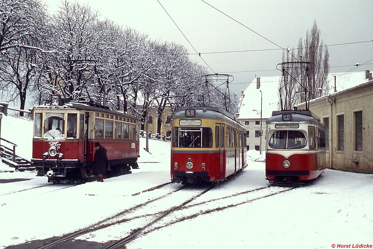 Fahrzeugparade der Innsbrucker Straßenbahn im Bergiselbahnhof im Januar 1980. Links ein für die Fahrt nach Igls bereitstenender Vierachser der 1909 ursprünglich für die Lokalbahn Innsbruck - Hall in Tirol bei der Wagen- und Waggonbabrik, Eisen- und Metallbedarf Joh. Weitzer in Graz beschafften Triebwagen 1-8. In der Mitte einer der von der Straßenbahn Hagen übernommenen DÜWAG Zweirichtungs-Sechsachser als Linie 1 zur Hungerburgbahn und rechts ein ebenfalls von DÜWAG hergestellter Vierachser als Linie 3/1 (Bf. Bergisel - Amras - Bf. Bergisel).