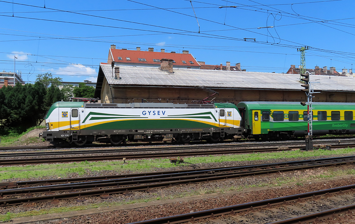Farbenfroher Reisezug: RaaberCity fährt in den Bahnhof Györ ein. Das Foto wurde von einer Strasse aus gemacht. Györ, 16.6.2023