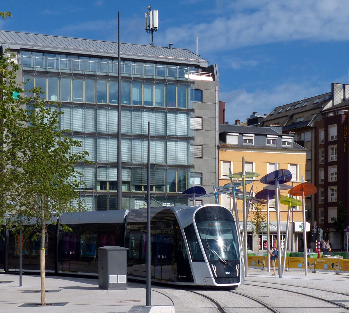 Farbige Straßenbahntüren und Schattenspender harmonieren perfekt - 29.7.2018 am Theater in Luxemburg.