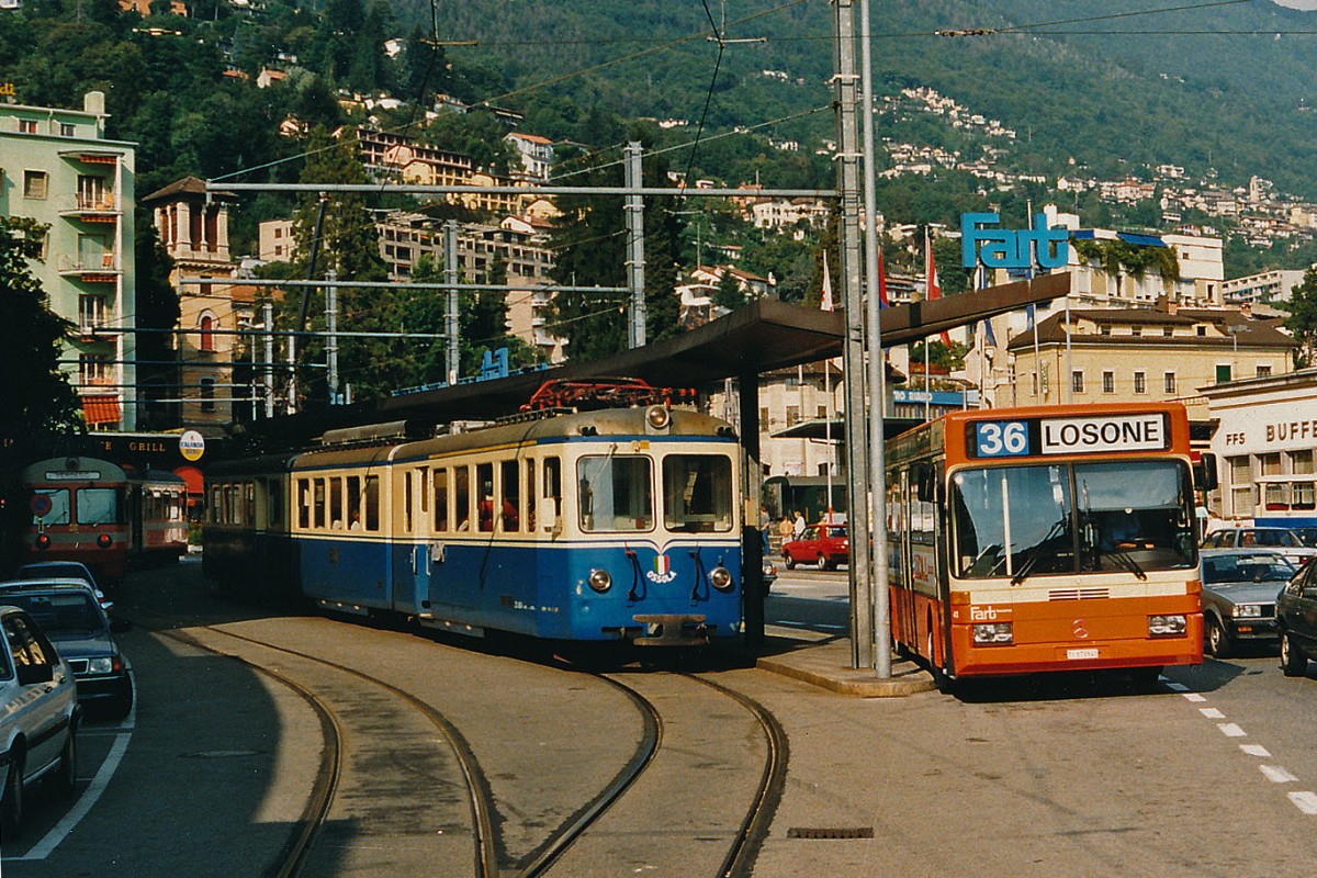 FART/SSIF: Während der Bauphase des neuen unterirdischen Kopfbahnhofs der FART wurde die provisorische Endhaltestelle Locarno zur Bushaltestelle vor dem F.F.S-Bahnhof verlegt. Da die Bahnanlagen neben dem Bahnhof entfernt wurden, konnten die Verstärkungswagen nur noch bis und ab dem Bahnhof Locarno S. Antonio mitgeführt werden. Die orange Farbe für Bahn und Bus hat sich bei der FART nicht durchgesetzt. ABe 8/8 23  OSSOLA  auf dem Bahnhofplatz Locarno zur Abfahrt bereit nach Domodossola im Oktober 1988.
Foto: Walter Ruetsch