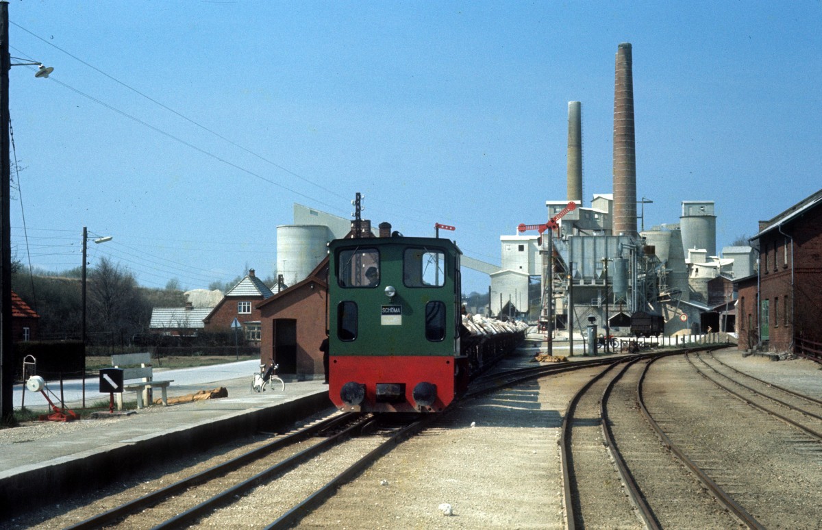 Faxe Jernbane, eine Schmalspurbahn (791mm) zwischen Stubberup und Fakse Ladeplads: Schöma-Diesellok mit Kipploren Stubberup am 24. April 1973. - Im Hintergrund die Kalkbrennerei der Firma Faxe Kalk. - Das Bahnunternehmen Faxe Jernbane wurde 1977 von der ØSJS (Østbanen) übernommen. 1982 endete der Kalktransport auf dieser 6km langen Strecke. Der Haltepunkt Stubberup auf der Bahnstrecke Hårlev - Fakse Ladeplads heisst heute Faxe Syd.
