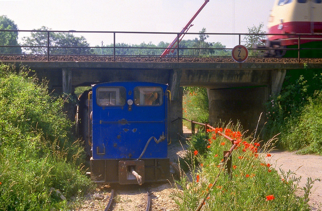 Feldbahn der Bonner Portlandcementwerke in Mainz Budenheim, Aufnahmedatum 20.06.1984. 
Man konnte die Bahn immer gut aus dem Zug sehen, irgendwann war dann mal ein Besuch angesagt. Der Steinbruch lag schwer erreichbar sdlich der Bahn, das Material wurde zum Werk am Rhein (mit Verladestelle auf's Schiff) auf 750mm transportiert. Die Strecke war nicht sehr lang und ansatzweise nur nahe der (im Bild mit einer 112 gezeigten) Unterfhrung unter der Rheinstrecke fotogen. Die Unterfhrung gibt es noch als letztes Relikt der 1985 eingestellten Bahn.