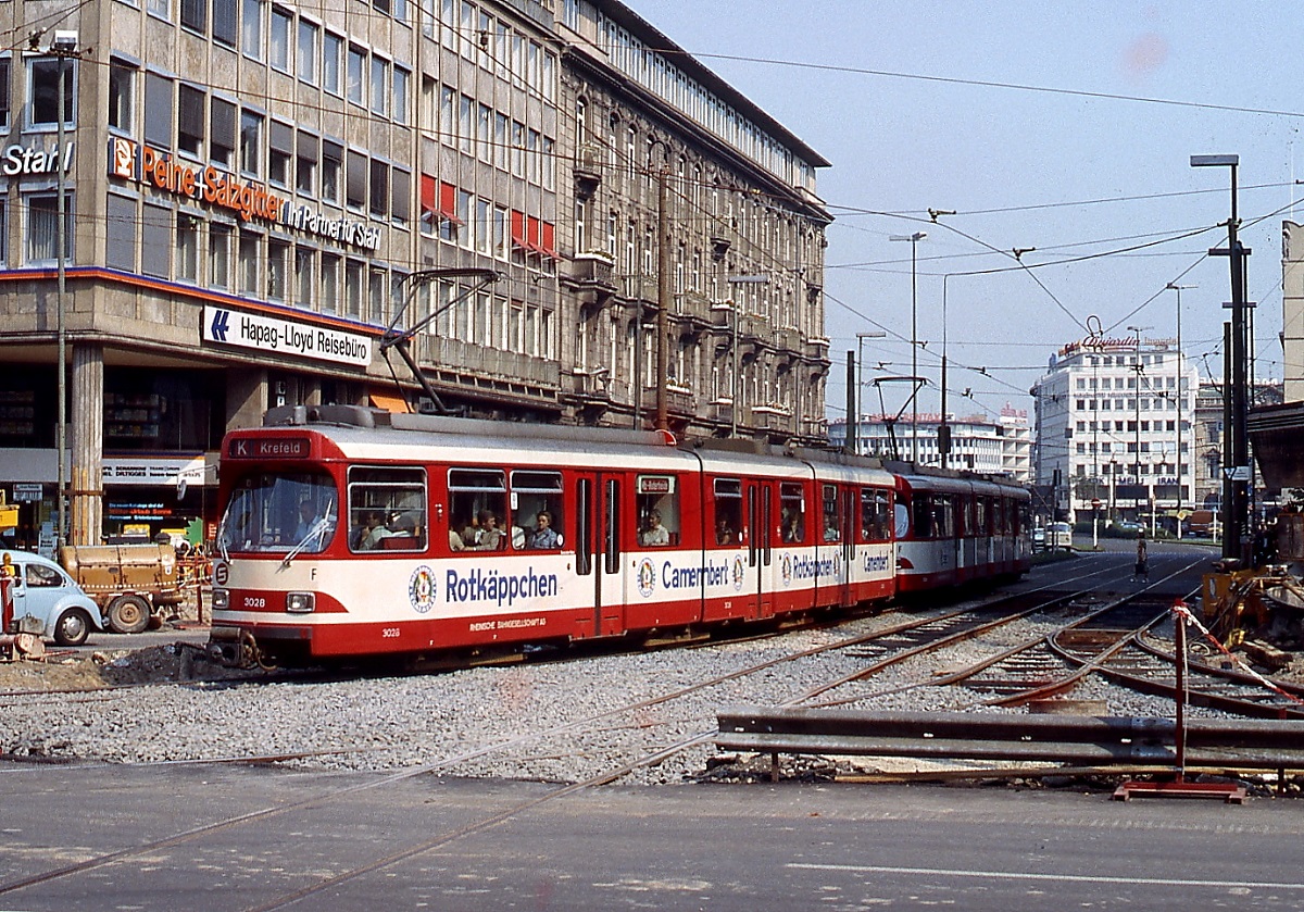 Fernbahnlinien der Düsseldorfer Rheinbahn: Mit der fortschreitenden Lieferung der GT8S verschwanden die bisher eingesetzten Tw von den Überlandlinien nach Krefeld und Duisburg, hier biegt Ende der 1970er Jahre eine damals neue GT8S-Doppeltraktion der Linie K nach Krefeld mit dem führenden Tw 3028 von der Elberfelder Straße in die Heinrich-Heine-Allee ein. Im Zusammenhang mit dem Bau des U-Bahn-Tunnels waren zu diesem Zeitpunkt Gleisbauarbeiten erforderlich.