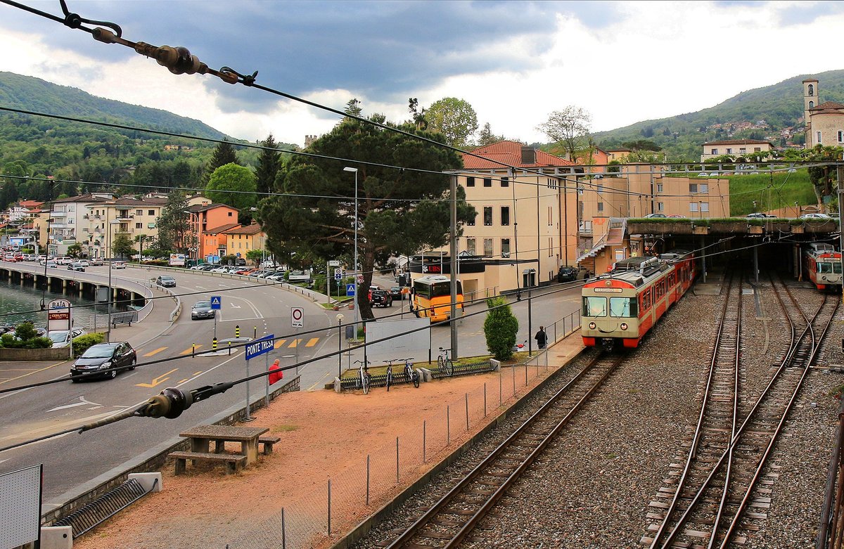 Ferrovia Lugano-Ponte Tresa: Zug 25 verlässt gerade die Endstation Ponte Tresa. Die Berge im Hintergrund sind bereits Italien, und die Autos am linken Bildrand stehen an der Grenzkontrolle Schweiz/Italien. 4.Mai 2019 