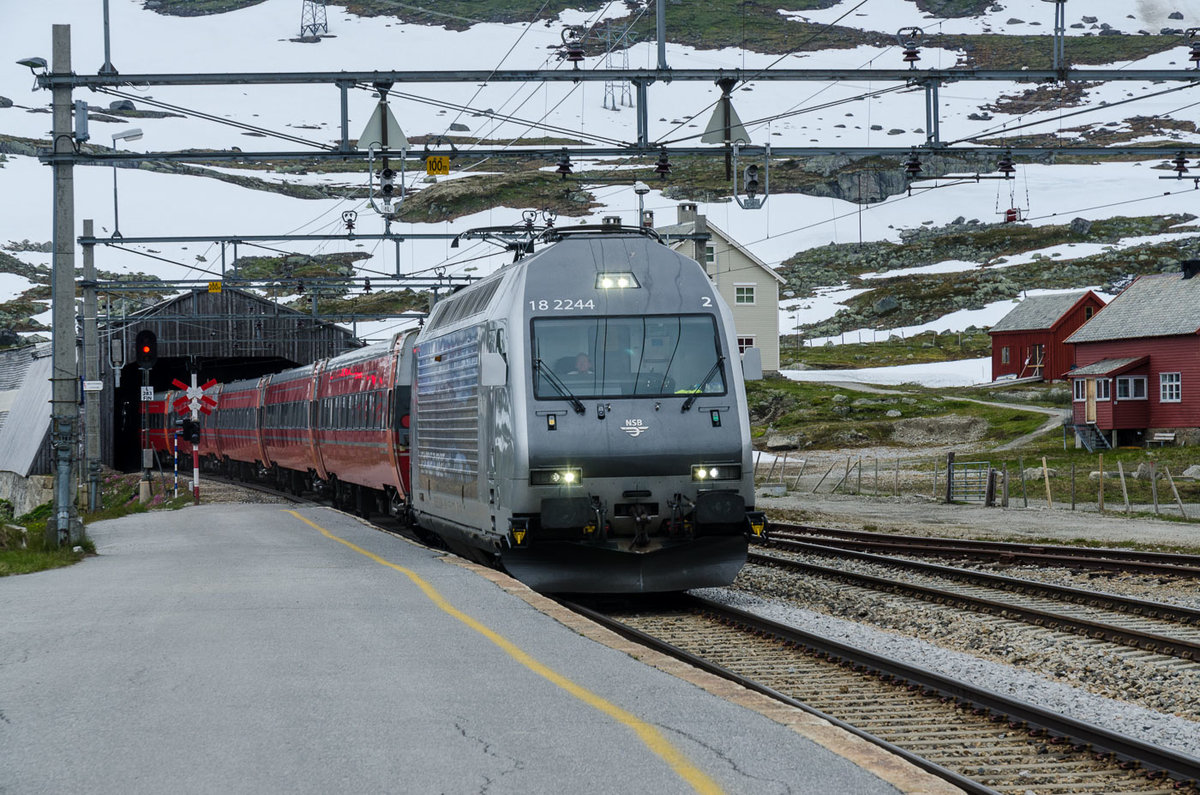 Finse / Bergenbahn: El18 2244 fährt aus dem Tunnel kommend im höchstgelegenen Bahnhof Nordeuropas ein. Nach kurzem Stop geht es weiter Richtung Oslo