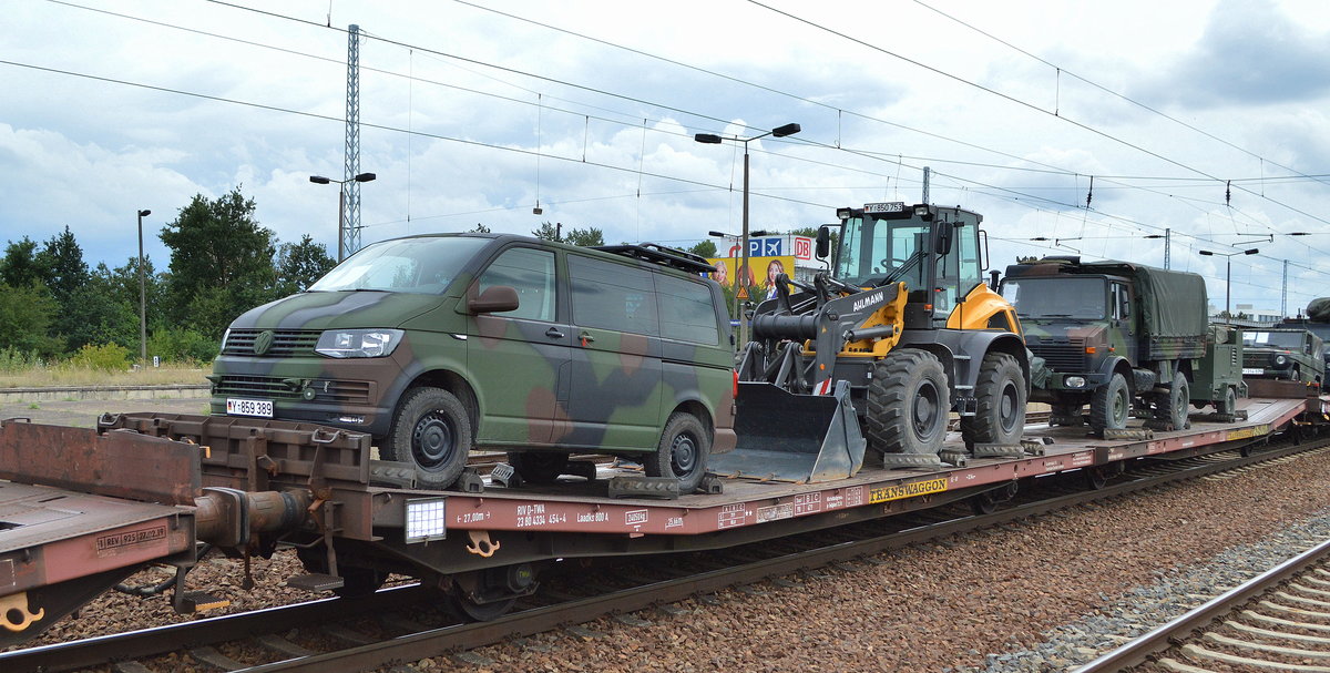 Flachwageneinheit mit abgesenktem Fußboden vom Einsteller TRANSWAGGON mit der Nr. 23 RIV 80 D-TWA 4334 454-4 Laadks 800 A beladen mit einem Bundeswehr VW Transporter, einem AHLMANN AS 1600 Radlader und einem MB UNIMOG U 1300 L + Hänger der Bundeswehr in einem Militärzug am 07.08.19 Bf. Flughafen Berlin Schönefeld.