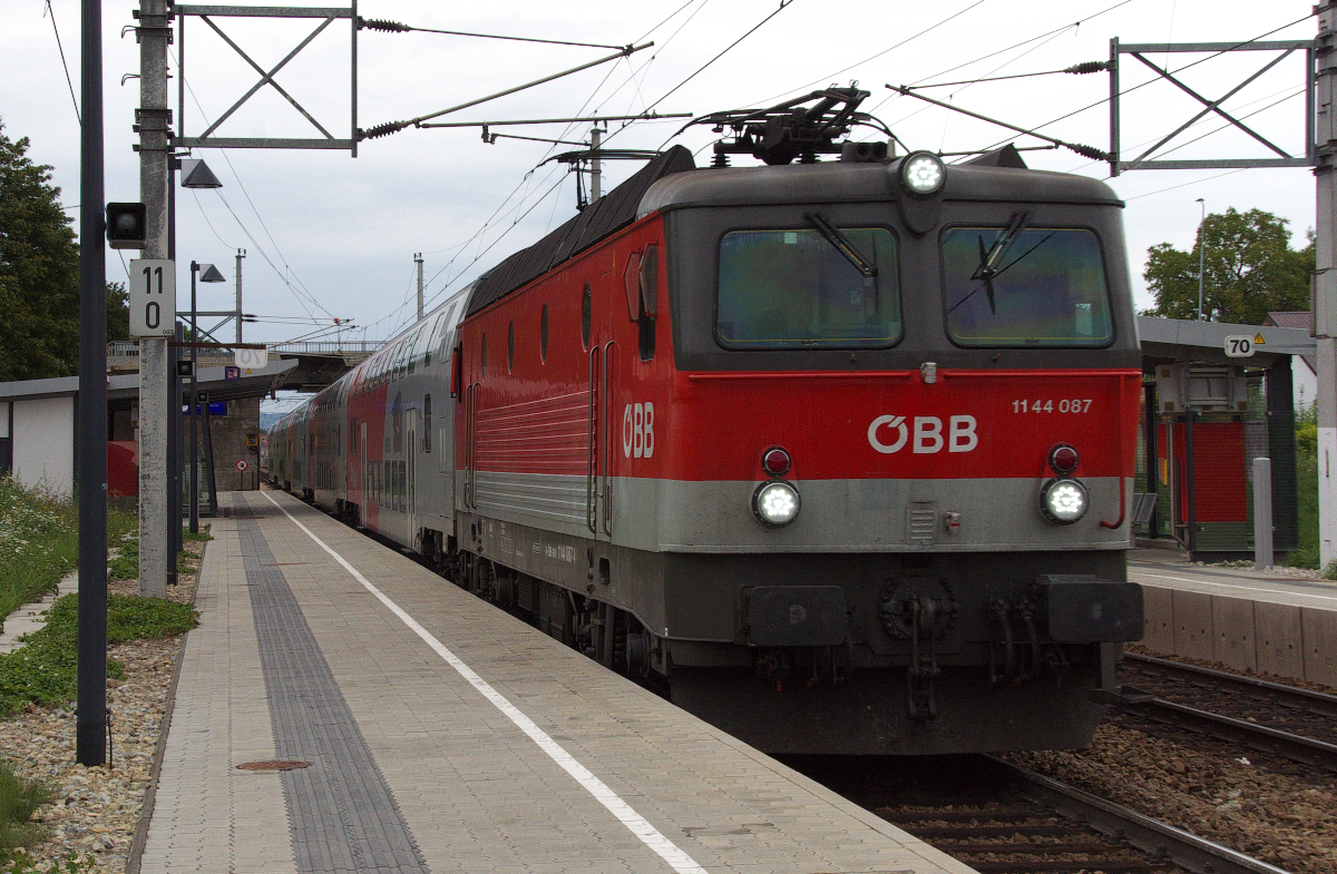 Flink wie ein Wiesel sind die Regionalzüge mit ihren Doppelstockwagen unterwegs.
Der Taurus hat den Stern der Baureihe 1144 (1044) sinken lassen aber die Maschinen sind immer noch das Rückgrat im rauen Betriebsalltag. 1144 087 zieht den Wiesel Regionalzug von Znojmo in Tschechien nach Payerbach-Reichenau am Semmering. Hier in Perchtoldsorf hat der Zug schon auf fast 120 Km/h beschleunigt. Bahnstrecke 105 01 Wien Hbf. - Spielfeld-Straß (Südbahn) am 20.08.2014