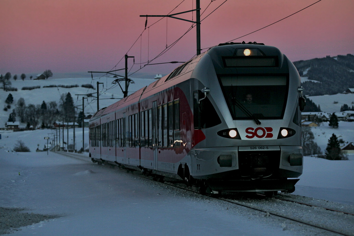 Flirt Triebzug 526 062-5  Chapfenberg  der SOB fährt bei starker Abendrotstimmung bei Schwyzerbrugg vorüber.Bild vom 9.2.2015