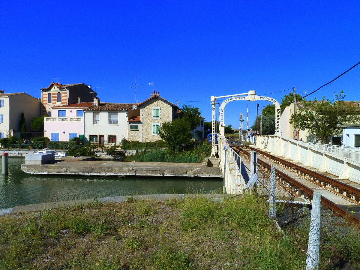 Frankreich, Languedoc, Gard, Aigues-Mortes. Die Drehbrücke über den Kanal auf der Eisenbahnlinie (Nîmes -) Saint-Césaire - Aigues-Mortes - le Grau-du-Roi. Nun kann der Triebwagen vom Grau du Roi nach Nîmes über den Canal du Rhône à Sète fahren. Fotografiert beim Kreisverkehr, den die Bahn hier durchquert (siehe Karte). 13.09.2014