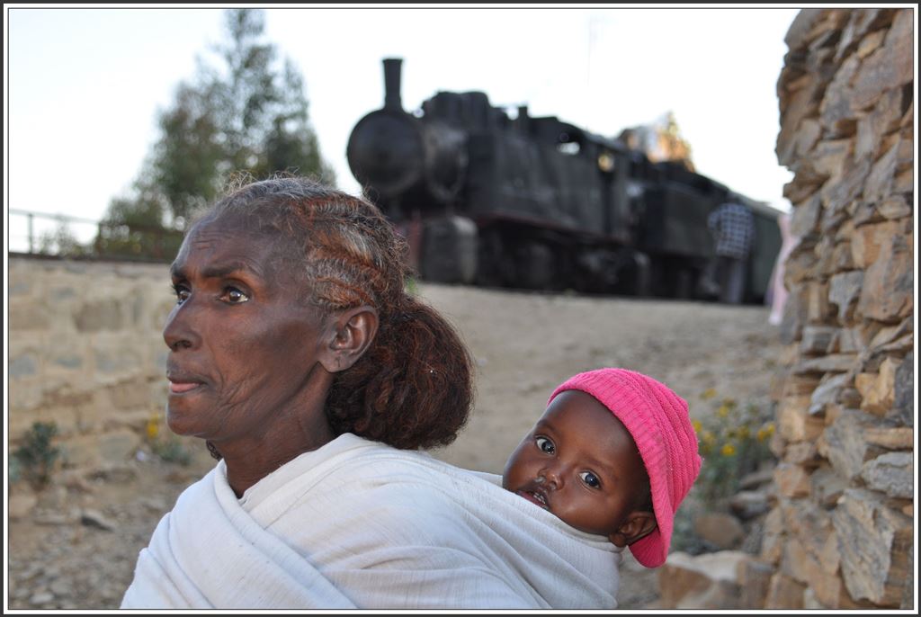 Frau Tsegay mit ihrem jüngsten Enkelkind nimmt den Bus in die Hauptstadt, während hinter ihrem Haus die Vorbereitungen für den  Doubleheader  laufen. Arbaroba. (10.12.2014)