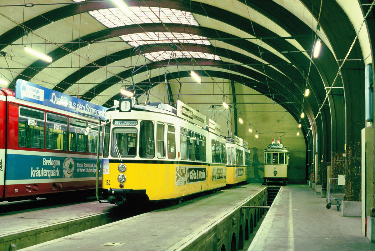 Freiburger Straßenbahn: In der Mitte zeigen sich stolz zwei frühere Stuttgarter Straßenbahnwagen (TW 154, und ein weiterer Wagen der Reihe GT4) und rechts daneben Museumswagen 2. 
Datum: 29.10.1986 