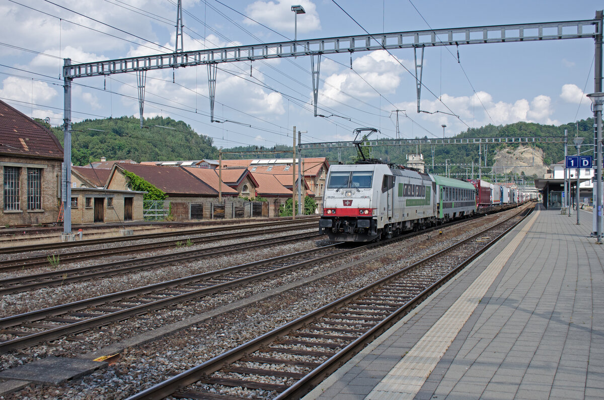 Freitag den 16.06.2023 um 15:55 Uhr in Burgdorf. Hier kommt der RoLa-Zug 43623 (sogar vier Minuten Vorzeitig). Fahrplanmässige Durchfahrt in Burgdorf wäre um 15:59 Uhr. RoLa bedeutet „Rollende Autobahn“: komplette Lastwagen werden an speziellen Terminals auf den Zug verladen und die Fahrer reisen in einem Begleitwagen mit. Dieser Zug verkehrt von Freiburg im Breisgau (D) über Basel – Olten - Bern – Thun – Brig – Domodossola nach Novara (I). Annahmeschluss in Freiburg ist um 11:15 Uhr. Entladebereit in Novara ist er um 22:30 Uhr. Zuglok ist die 91 80 6186 903-1 D-BLSC (DB Baureihe 186 903, BLS 486). Hersteller: Bombardier. Typ: TRAXX F140 MS. Fabriknummer: 34354. Baujahr: 2007. Inbetriebnahme: 2008. Der Begleitwagen für die LKW-Fahrer ist der Bcm 61 85 5900 100-2 CH-RALP. Dieser Wagen ist Klimatisiert. Koordinaten GMS (Grad, Minuten, Sekunden): N 47° 3’ 39.1’’ O 7° 37’ 8.4’’