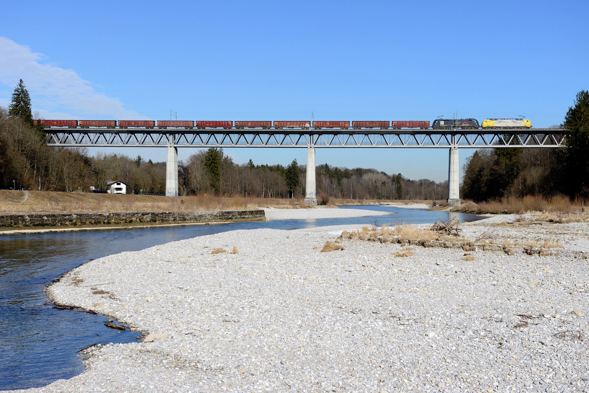 Freitags verkehrt seit kurzem eine TXLogistik Leistung in Richtung Brenner über das Mangfalltal. Zur Mittagszeit des 27. Februar 2015 überqueren ES 64 F4 031 und ES 64 U2 099 mit ihrem 48817 die Grosshesseloher Eisenbahnbrücke am Stadtrand von München. Ladegut des Ganzzuges ist Schrott.