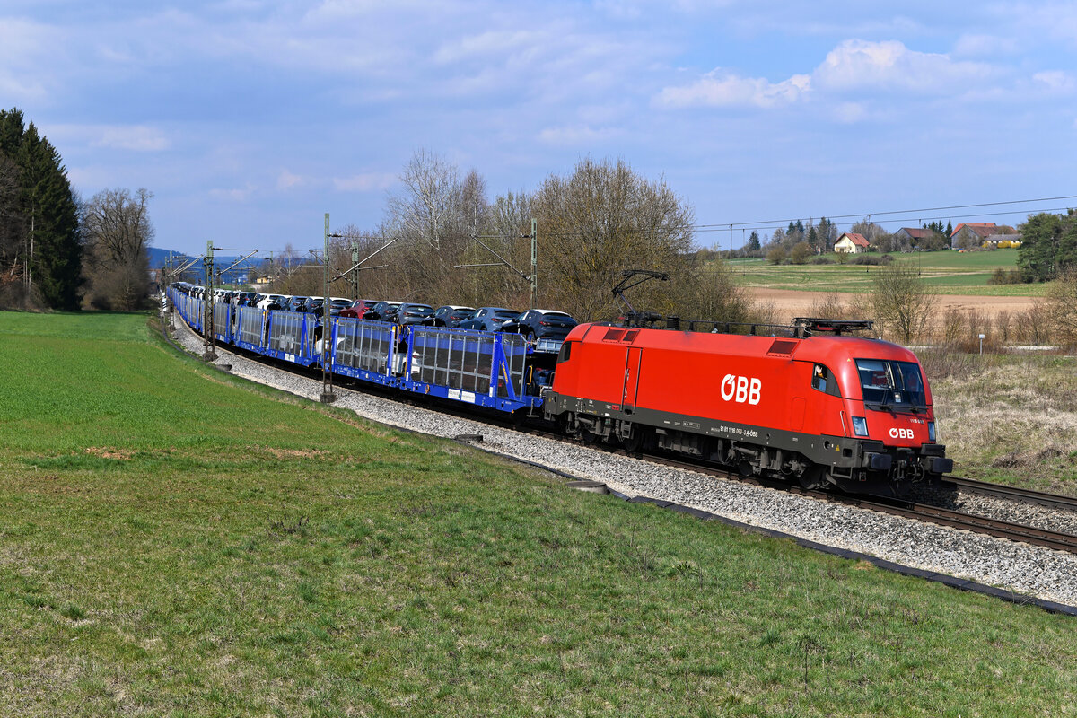 Freundlich grüßend passierte der Lokführer der 1116.099 am 07. April 2023 meinen Standort bei Sinngrün in der Oberpfalz. Der ÖBB-Taurus hatte einen Hödlmayr Neuwagentransport am Haken. Ladegut waren Fahrzeuge des japanischen Herstellers Mazda.  