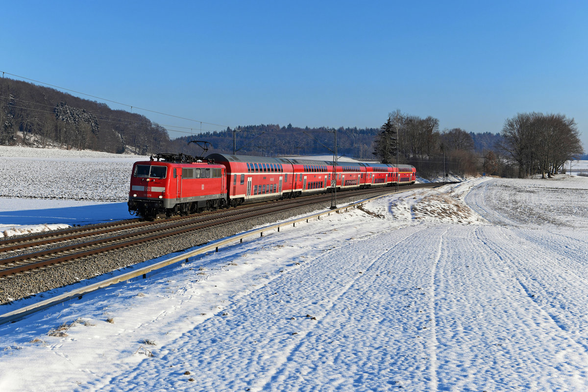 Frostig war es am Morgen des 12. Februar 2021, als bei Kottgeisering die Durchfahrt des RE 57406 nach Memmingen abgewartet wurde. Zuglok war an diesem Tag die 111 076. Diese Maschine war längere Zeit in Stuttgart beheimatet, ist seit Ende 2019 aber wieder dem Betriebshof München West zugewiesen. 