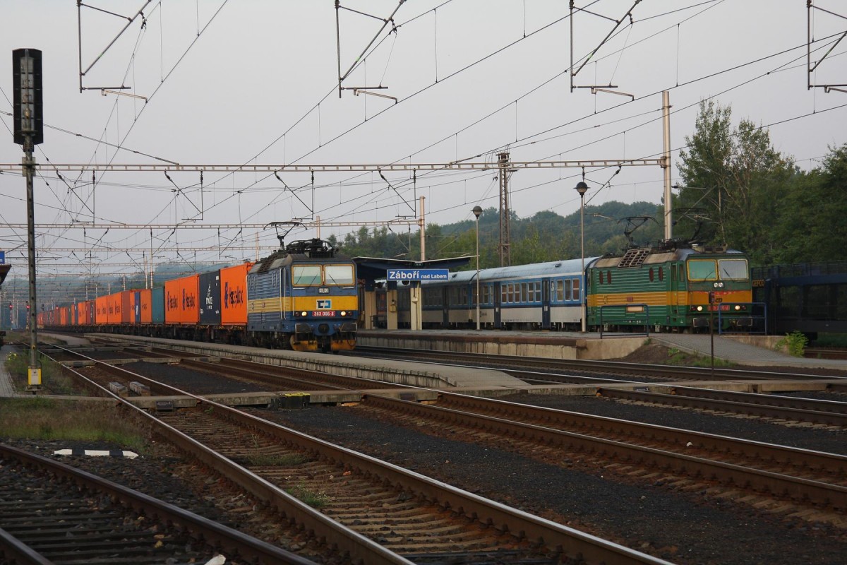 Früh morgens beginnt im Bahnhof Zabori nad Labem sogar ein Os in Richtung Pardubitz. Während der hier eingesetzte Zug am 23.8.2013 am Bahnsteig wartet, fährt CD 363006 mit einem Container Zug in Richtung Pardubitz vorbei.