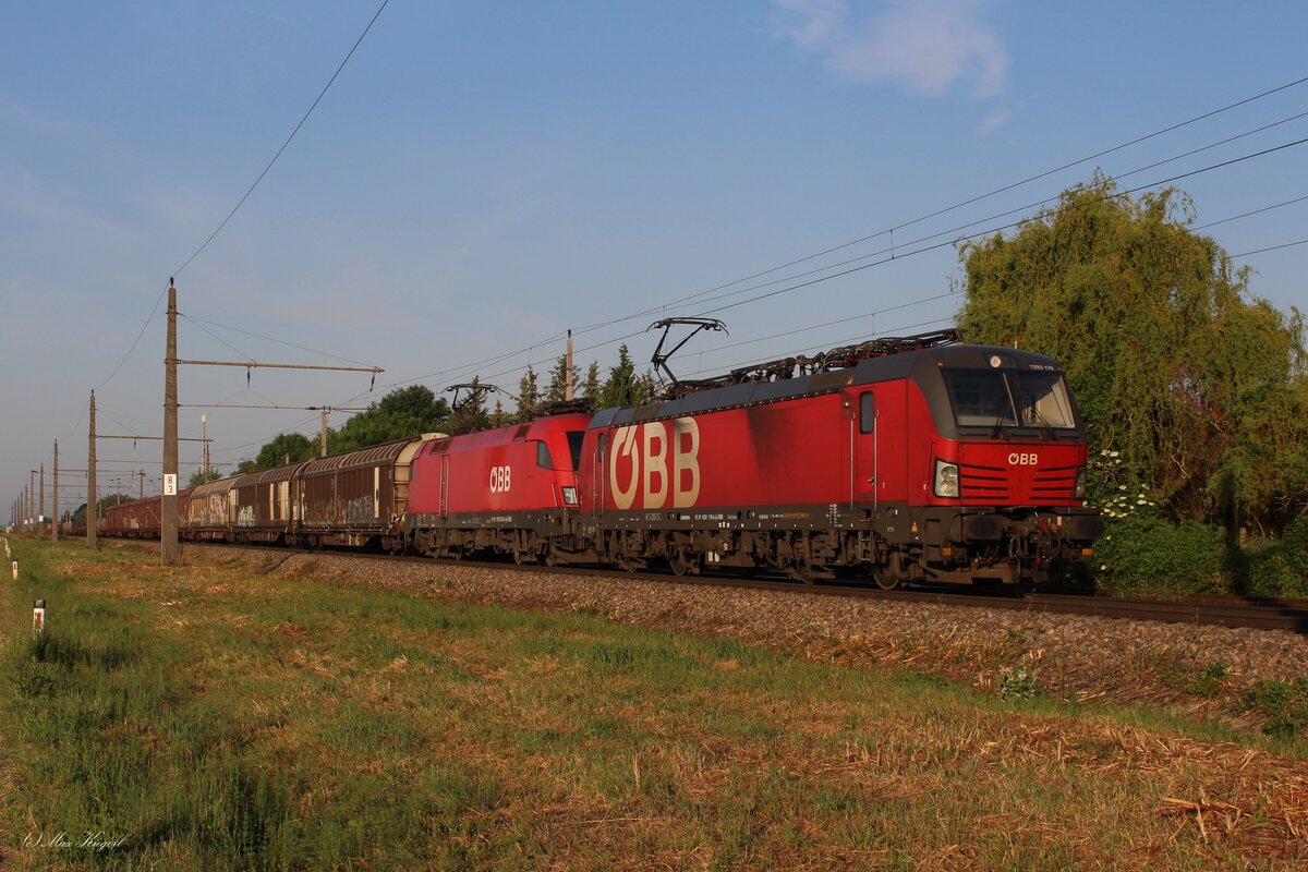Früh morgens im ersten Sonnenschein des 2.6.2023 warten die 1293 179 und die 1016 042 mit dem DG54072 von Graz Vbf nach Wien Zvb im Bahnhof Mitterndorf-Moosbrunn auf die Kreuzung mit einem Güterzug und auf die Weiterfahrt in Richtung ihres Zieles.