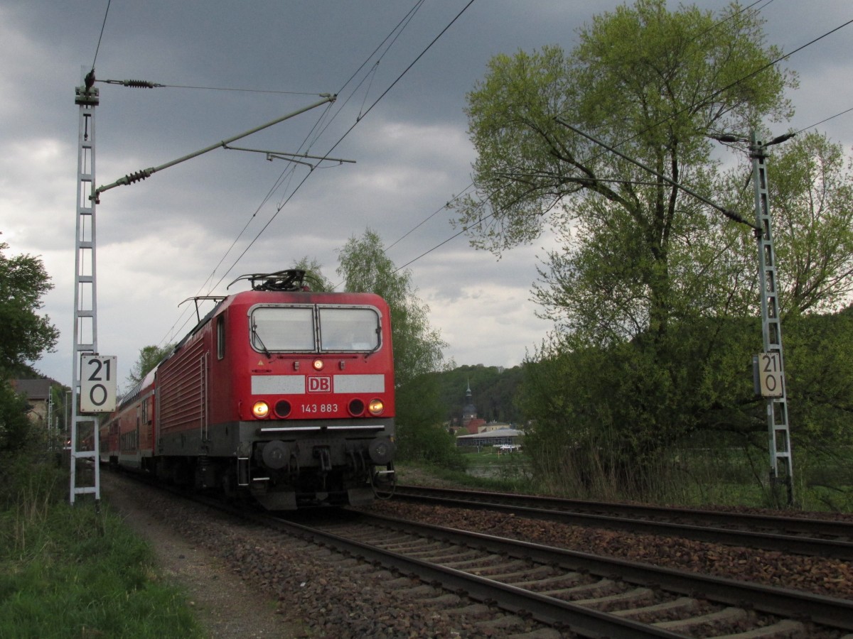 Frühling von Gewitterwolken eingetrübt. Die S1 nach Schöna fährt immer. Mit der 143 883 als Zuglok wurde dieses Foto in Krippen am 27.04.2015 aufgenommen. 