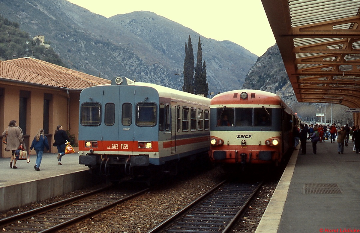 FS ALn 663 1159 und SNCF X 4534 im Bahnhof Breil sur Roya der Tendabahn (März 1987). Diese Bahn in den Seealpen durch das französisch-italienische Grenzgebiet verbindet Turin und Nizza, in Breil sur Roya zweigt eine Linie nach Ventimiglia ab. Kaum eine andere Bahnlinie hat eine ähnlich bewegte Geschichte: erst 1928 ereöffnet wurde sie Mitte der 1930er Jahre elektrifiziert und nach schweren Zerstörungen im 2. Weltkrieg stillgelegt. Der Verkehr auf der Bergstrecke wurde erst 1979 wieder aufgenommen.