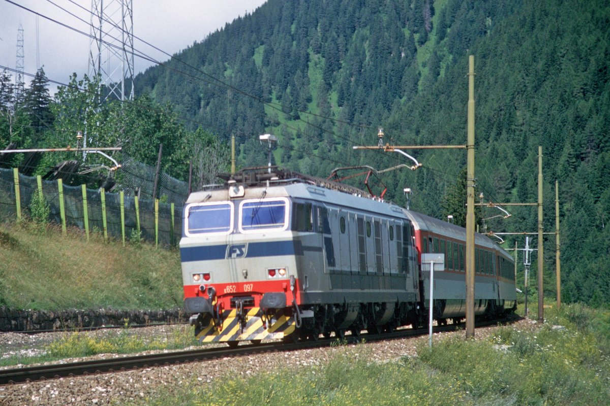 FS E 652 097 mit DB-EC in Richtung Bozen (Nähe ehemalige Hst Schelleberg [oberhalb von Gossensaß] 23.07.1999); digitalisiertes Dia. - Im November 1999 wurde der ca. 7 km lange Pflerschtunnel freigegeben und die alte oberirdische Strecke von Brennerbad über Schelleberg bis zum Aster Tunnel stillgelegt. Sie wurde zu einem Radweg umgebaut und ist Teil des Eisacktalradweges vom Brenner bis nach Bozen. 