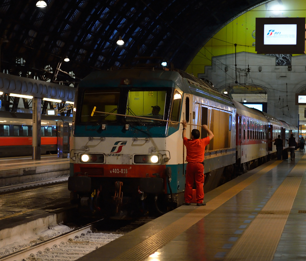 FS E.402A 028 stand am Abend des 16. September 2013 mit dem ES 9753, welcher Schlafkurswagen nach München und Wien führte in Milano Centrale bereitgestellt.
Vor stand aber noch die obligate Windschutzscheibenreinigung auf der Agenda. ;)