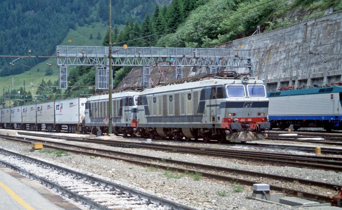 FS-Trenitalia E.652 056 und E.652 XXX haben einen Roadrailerzug der BTZ (Bayerische Trailerzug Gesellschaft fr bimodalen Gterverkehr) bernommen und warten auf die Abfahrt in Richtung Bolzano/Bozen (Bahnhof Brennero/Brenner, 29.06.2000); digitalisiertes Dia. - Diese Form des Transports von Sattelaufliegern, bei dem der vordere und hintere Teil auf je einem speziellen Drehgestell ruht, hatte sich nicht bewhrt und wurde nach einigen Jahren wieder eingestellt. Die BTZ musste in der Folge Insolvenz anmelden.