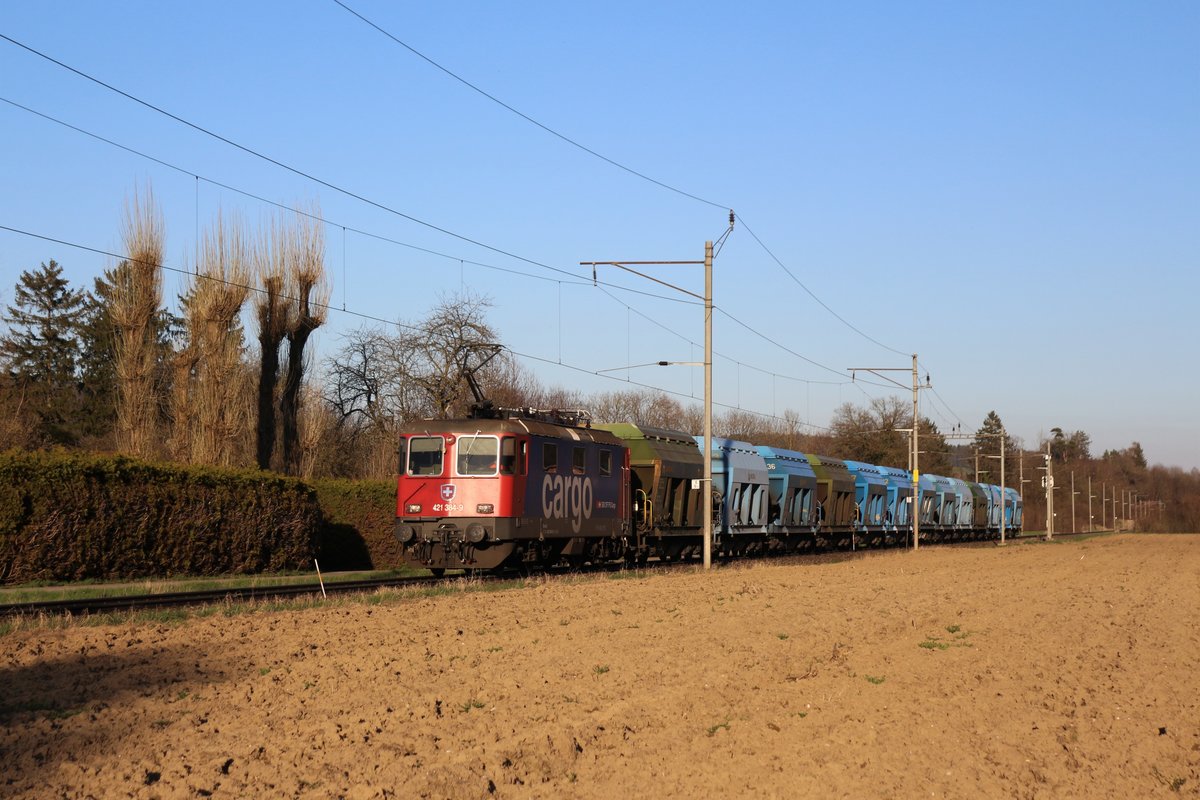 Für diesen recht ungewöhnlich kurzen Kiesgüterzug nach Hüntwangen-Wil wurde am 6. April 2018 statt einer Re 6/6 eine SBB Re 421 vorgespannt. 

Die SBB Re 421 384-9 durchfährt unter den letzten Sonnenstrahlen mit einem Kiesgüterzug, in wenigen Sekunden den Bahnhof Pfungen. 