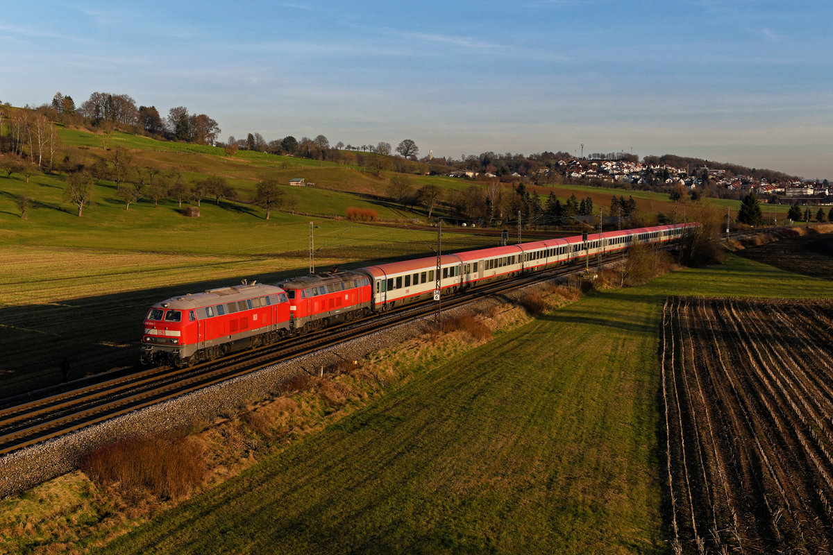 Für den dreiwöchigen Einsatz des IC 118/119 über Lindau hinaus von und nach Stuttgart wurden einige 218er angemietet, da der Lokbestand vor allem in Ulm äußerst angespannt war. Leider liefen die Leihloks nicht besonders zuverlässig, insbesondere die Zugheizung machte Probleme. Rühmliche Ausnahme war das hier zu sehende Doppel, bestehend aus 218 824 von DB Fernverkehr und der 218 488 von Railsystems. Beide Maschinen funktionierten über den Zeitraum hinweg klaglos und drehten ihre Runden vor den IC 118/119, IC 2012/2013 und IC 2084/2085 im Allgäu und im Schwäbischen. Am 29. Dezember 2019 gelang mir bei Uhingen ein Foto des Tandems vor dem IC 118 im schönsten Abendlicht. Hinter der 218 824 verbirgt sich übrigens die 218 233, eine Lok der zweiten Bauserie, was man beim Blick auf das Dach und die Drehgestelle auch unschwer erkennen kann. 