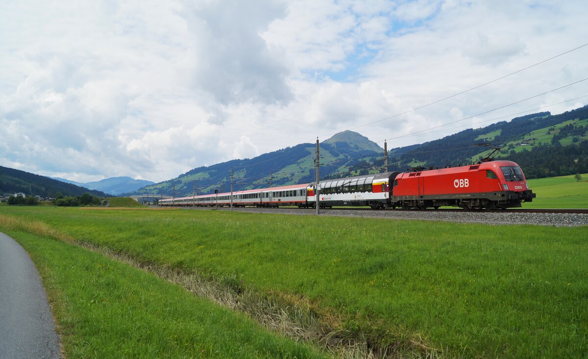 Für die Führung des EC 163  Transalpin  (Zürich HB - Graz Hbf) war am 25.07.2020 die 1116 263 zuständig, die ihre Leistung hier kurz vor dem Halt in Kirchberg in Tirol durch die Wiesen des Ortsteils Bockern führte. Heute wird der Transalpin mit Wagen der SBB betrieben.