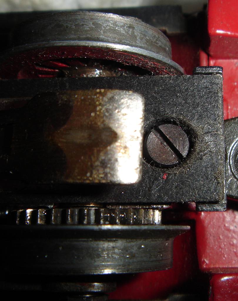 Für die hintere Laufachse der TP 800.1 gibt es ebenfalls eine solche Schraube, nur ist die halb unter dem Schleifer versteckt, sodass man einen schlanken Schraubendreher verwenden muss, um sie zu entfernen. Ein dick mit Kunststoff armierter Elektriker-Schraubendreher versagt an dieser Stelle. Aufnahme 28.09.2014