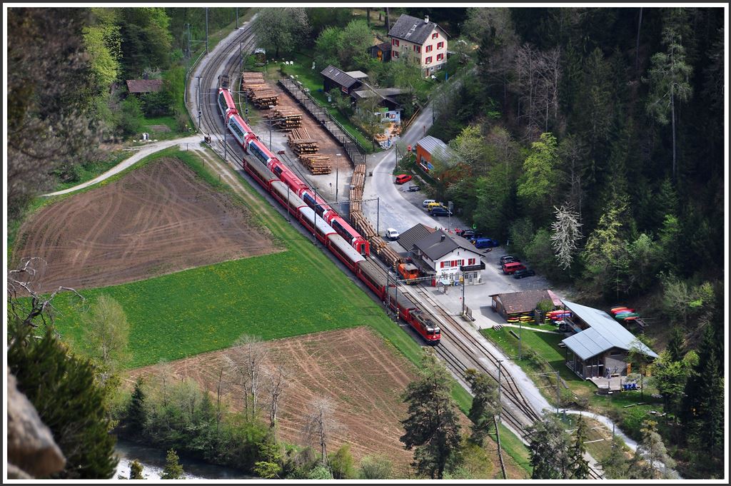 Fullhouse in Versam-Safien. Der Glacier Express 902 kreuzt hier planmässig den RE 1236 mit der Ge 4/4 II 625  Küblis . Zudem holt der Tm aus Ilanz beladene Stammholzwagen ab und stellt leere Wagen ins Verladegleis. (27.04.2015)