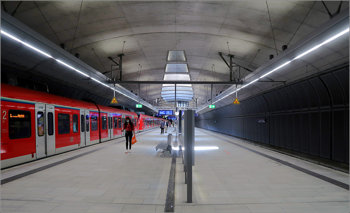 Gateway Gardens - ein neuer Tunnelbahnhof in Frankfurt - 

Ein Blick in die großzügige Bahnsteighalle der S-Bahnstation 'Gateway Gardens' mit ihrem ovalen Querschnitt. Sichtbeton ist das vorherrschende Material, über Öffnungen in der Decke fällt Tageslicht in den Bahnsteig.

21.07.2021 (M)