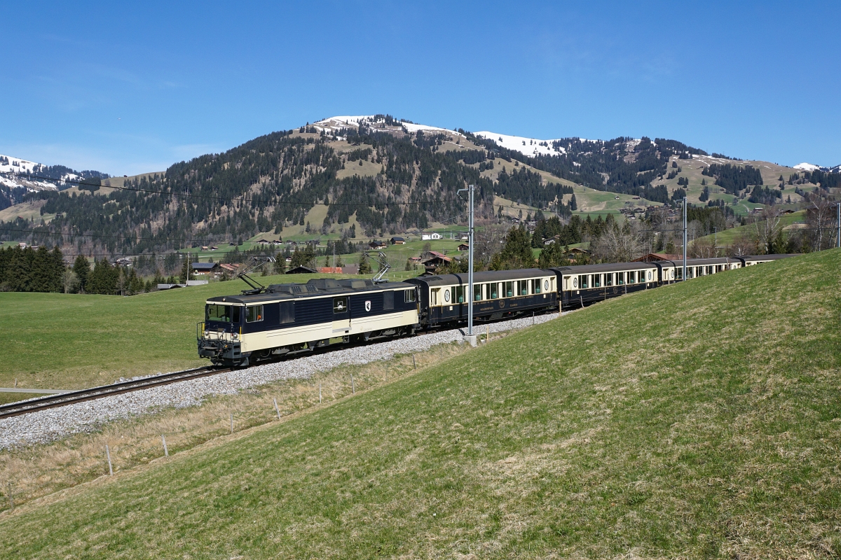 GDe 4/4 6004 nähert sich am 12.04.2015 mit dem GoldenPass Classic Gstaad. Da es sich beim letzten Wagen wieder um einen nicht passenden goldenen gehandelt hat, habe ich versucht, diesen mit Hilfe der Kurve verschwinden zu lassen.