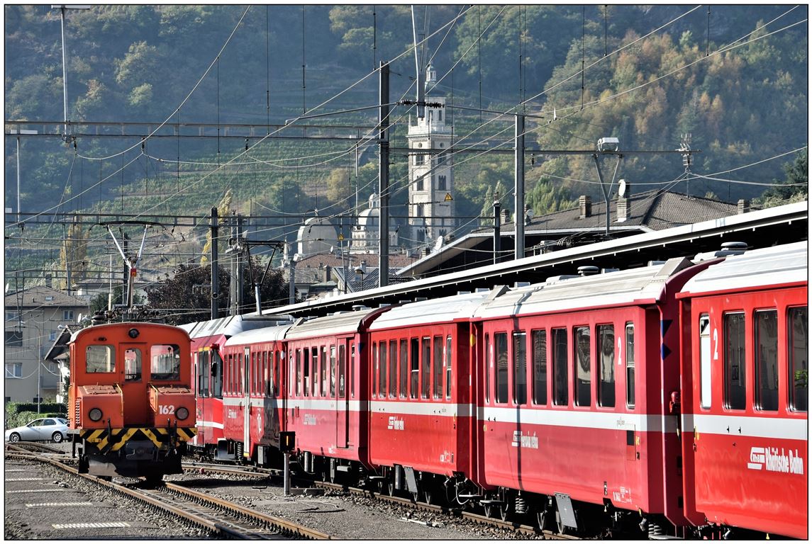 Ge 2/2 162 wartet auf weitere Rangieraufgaben. Im Hintergrund ist der Turm der Madonna di Tirano zu sehen, wo die RhB Richtung St.Moritz vorbeifährt. (14.10.2018)