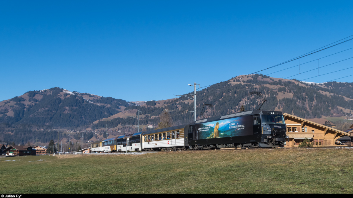 Ge 4/4 8003 mit Werbung für das Menuhin-Festival erreicht am 30. Dezember 2015 mit einem Regio aus Montreux Gstaad.