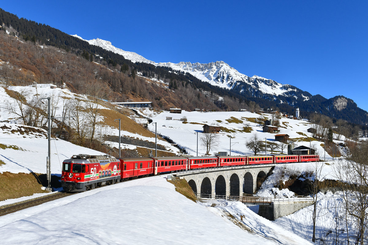 Ge 4/4 II 617 mit einem Regio am 13.01.2018 bei Saas. 
