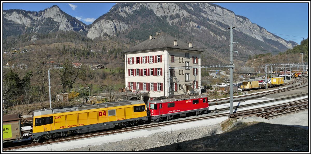 Ge 4/4 II 624  Celerina/Schlarigna  hat Gmf 4/4 23404 D4 im Schlepp. Hinter der Lok das sogenannte Beamtenhaus am Bahnhof Reichenau-Tamins. (02.04.2020)